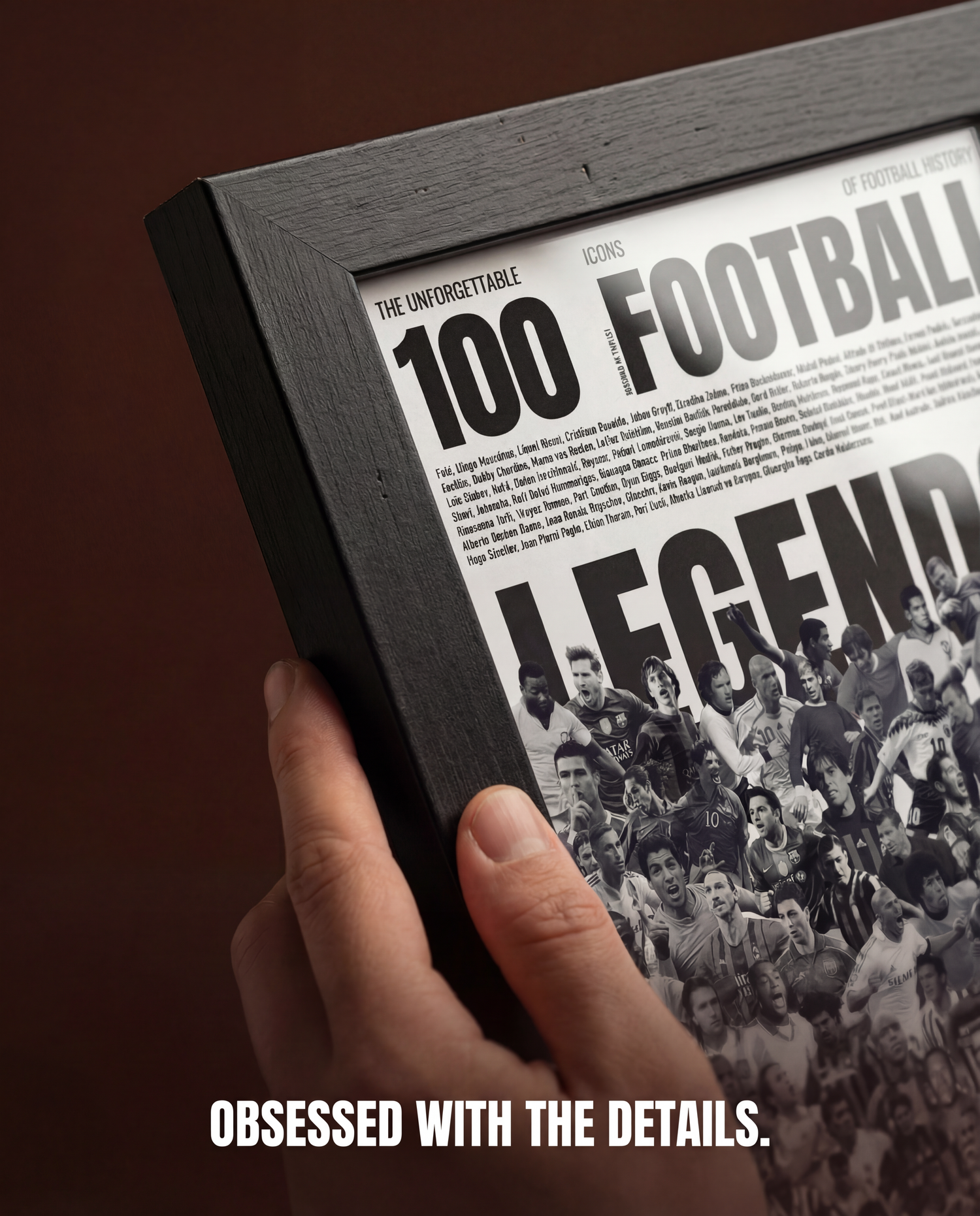 Hand holding framed football legends poster featuring famous players and bold typography